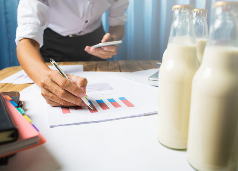 Business man working at milk bottle quality control hard job concept, quantity checking in the office, Facility layout planning in the future.